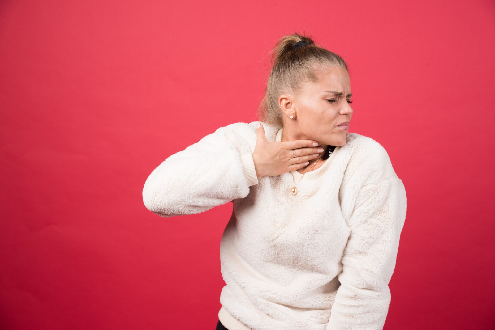 Feature image A young woman holding throat and suffering from pain. Swollen Lymph Nodes: Symptoms, Causes, Diagnosis & treatment